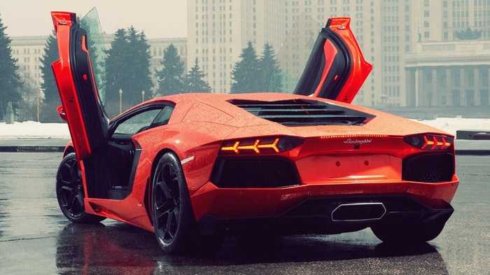 Red Lamborghini Aventador with doors open in the rain