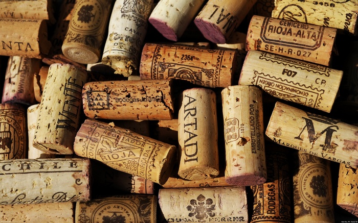 Pile of used wine corks with labels