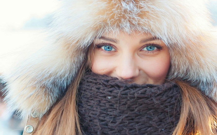 Woman with blue eyes wearing a fur hat and scarf