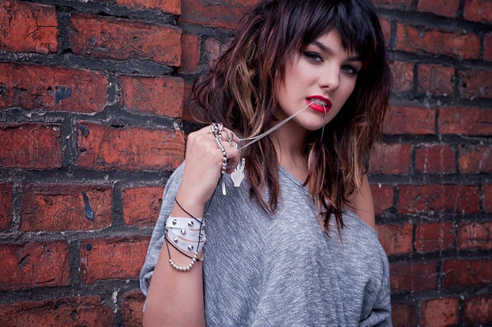 Ewa Farna chewing gum in front of a brick wall