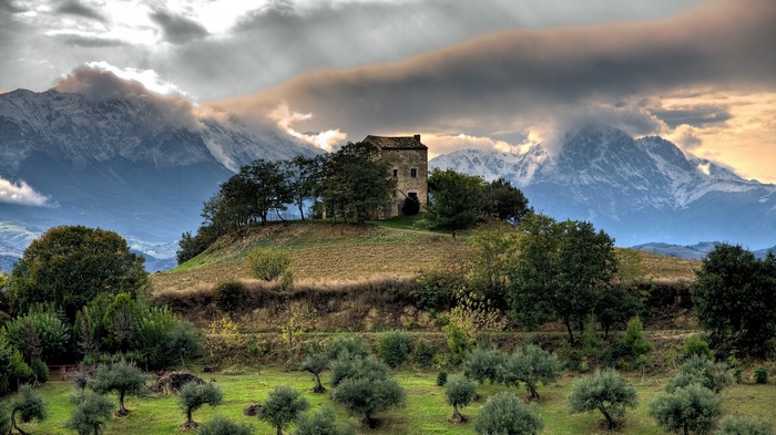 Old building on a hill in Italy with mountains