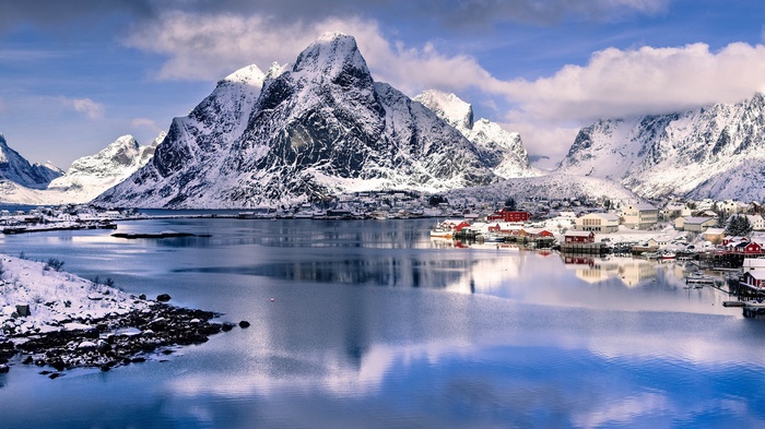 Snowy mountains and village by a fjord in Norway