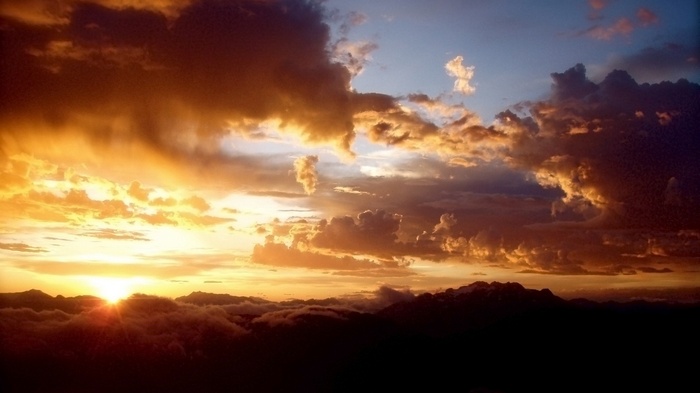 Sunset over mountains with dramatic clouds