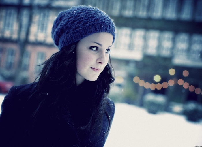 Young woman wearing a blue knit hat in the snow