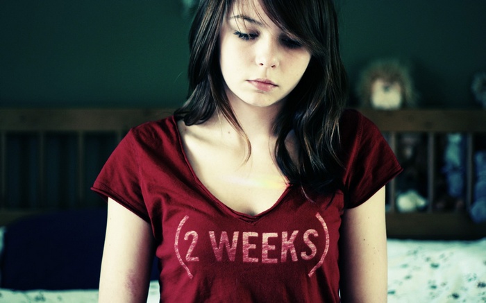 Young woman wearing a red t-shirt with "2 WEEKS" text