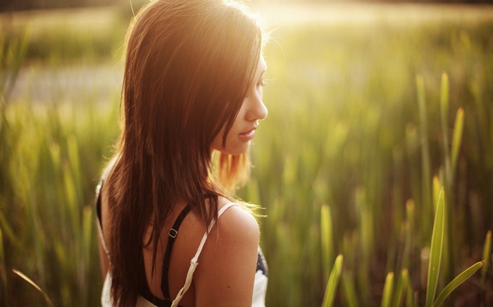 Brunette woman in a field at sunset
