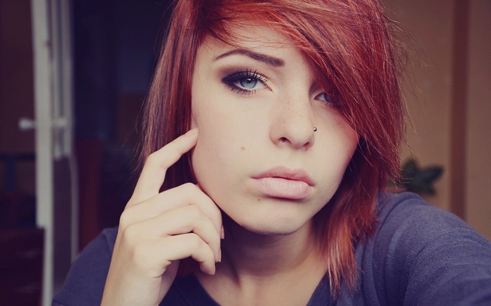 Redhead woman with blue eyes and nose piercing