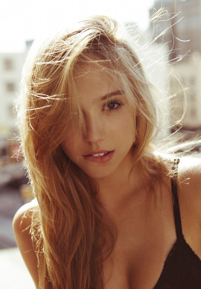 Alexis Ren with long auburn hair biting her lip
