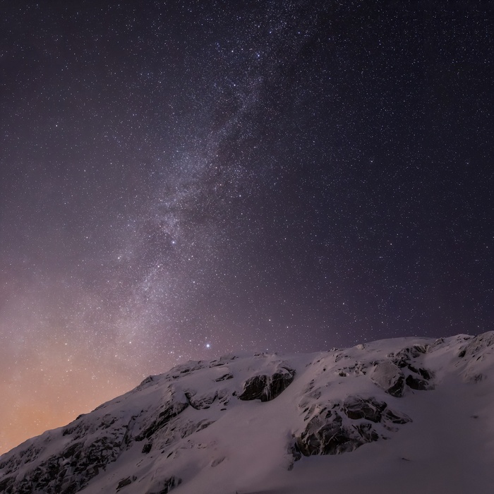 Snowy mountains under a starry night sky