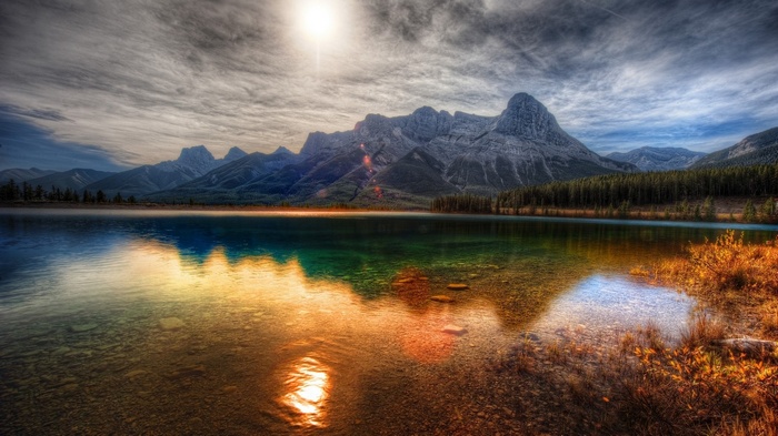HDR landscape of mountains reflecting in a lake at sunset