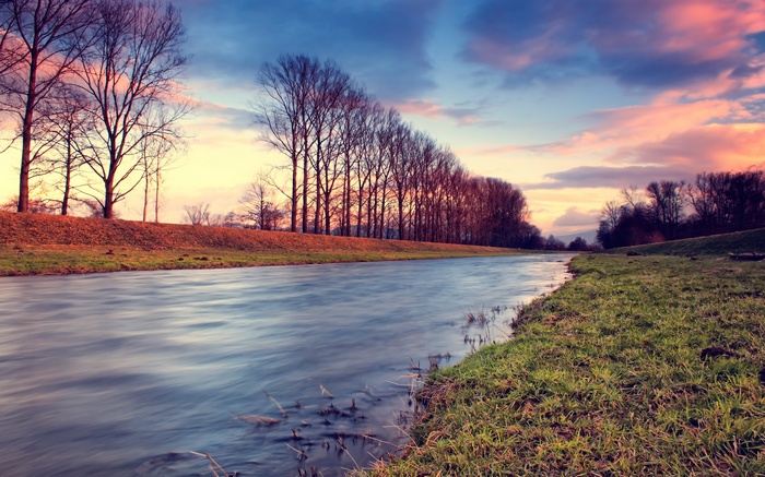 River landscape with trees and clouds at sunset
