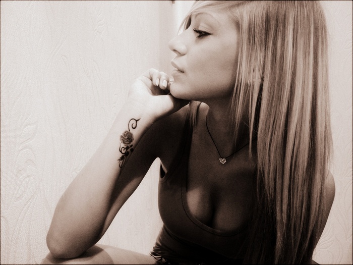 Woman with blonde hair and rose tattoo
