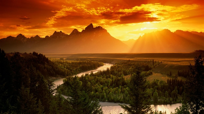 Sunset over mountains with river and forest