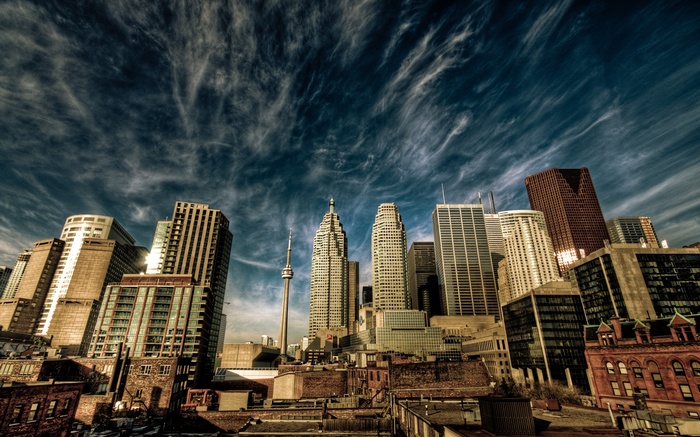 Toronto cityscape with CN Tower and skyscrapers under cloudy sky