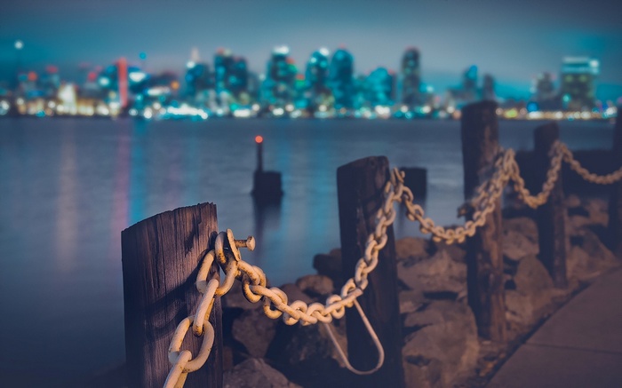 Night cityscape across the water with chains