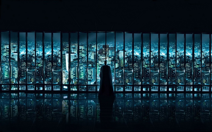 Batman overlooking a futuristic cityscape at night