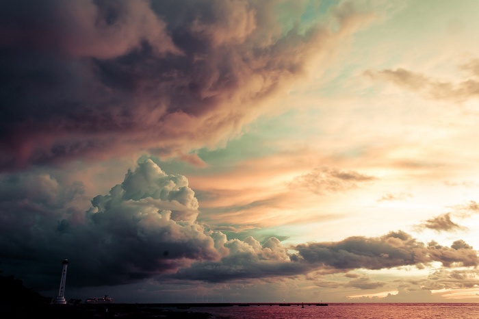 Dramatic clouds over the ocean with a lighthouse