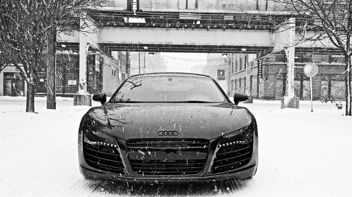 Audi R8 in the snow under an elevated train track