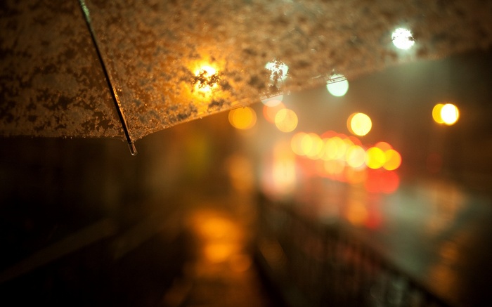 Umbrella in the rain at night with bokeh lights