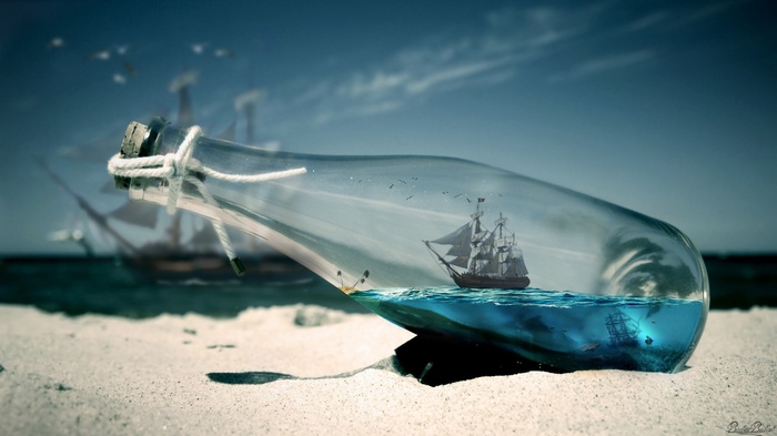Sailing ship in a bottle on a sandy beach