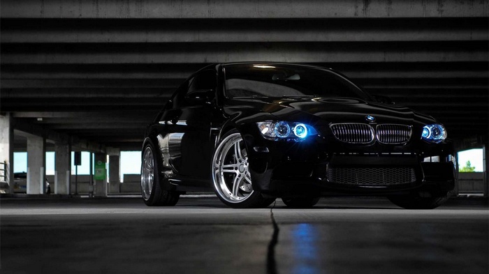 Black BMW M3 parked in a dark garage