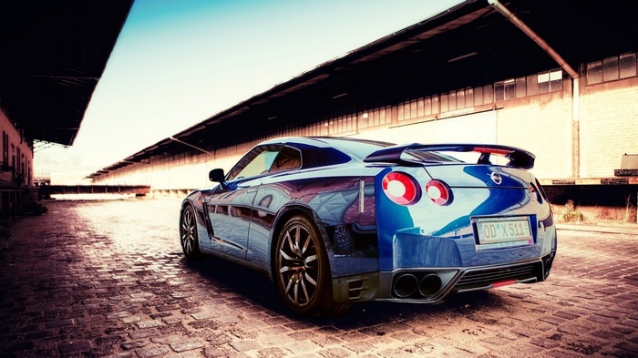 Blue Nissan GTR parked on cobblestone street