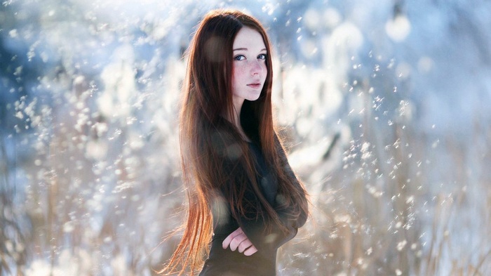 Redhead woman with freckles in the snow