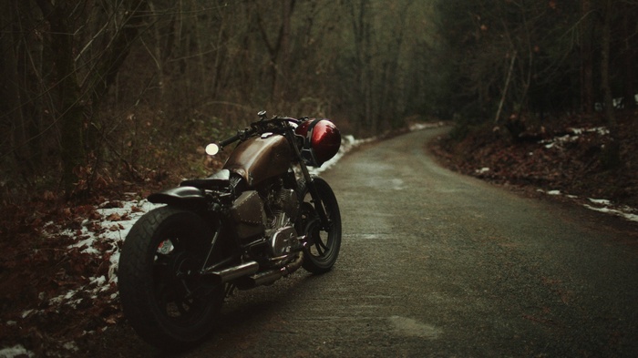 Bobber motorcycle on a snowy forest road