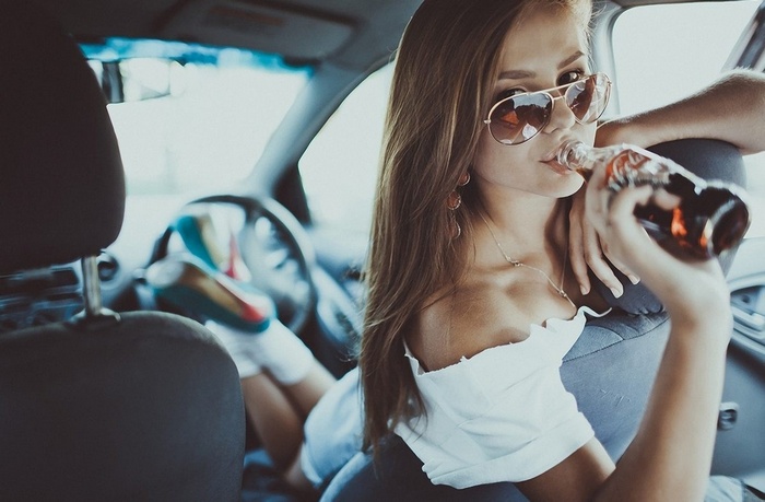Woman drinking Coca-Cola in a car