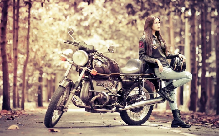 Woman in leather jacket with BMW R100S motorcycle