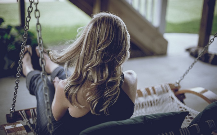 Woman on a porch swing outdoors