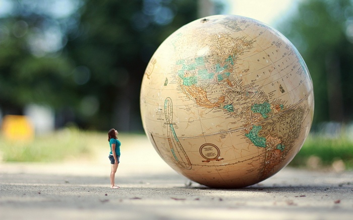 Woman looking up at a giant globe