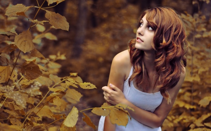 Woman with curly hair looking up in nature