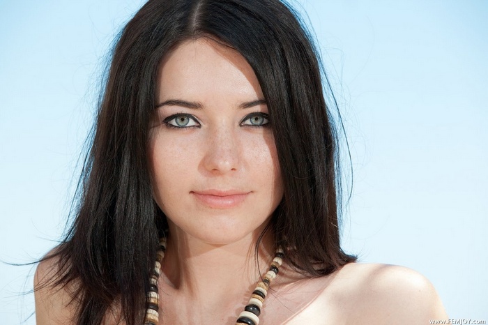 Elza with dark hair and blue eyes wearing a necklace