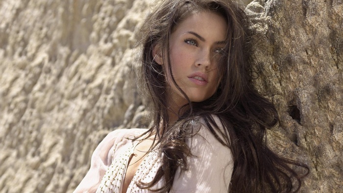 Megan Fox leaning against a rock face