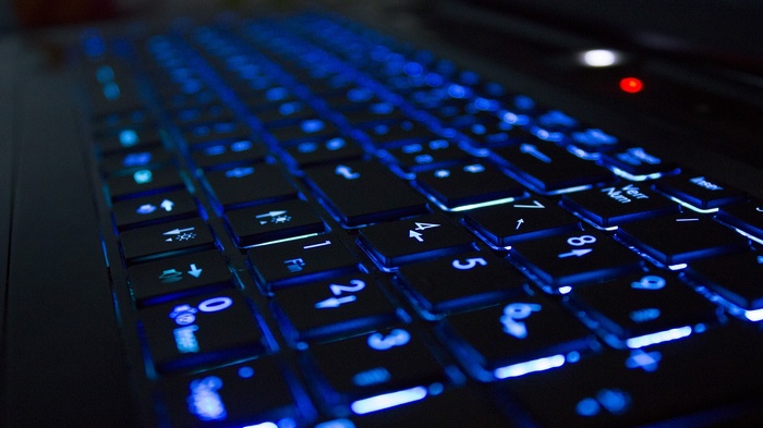 Close-up of a laptop keyboard with blue backlighting