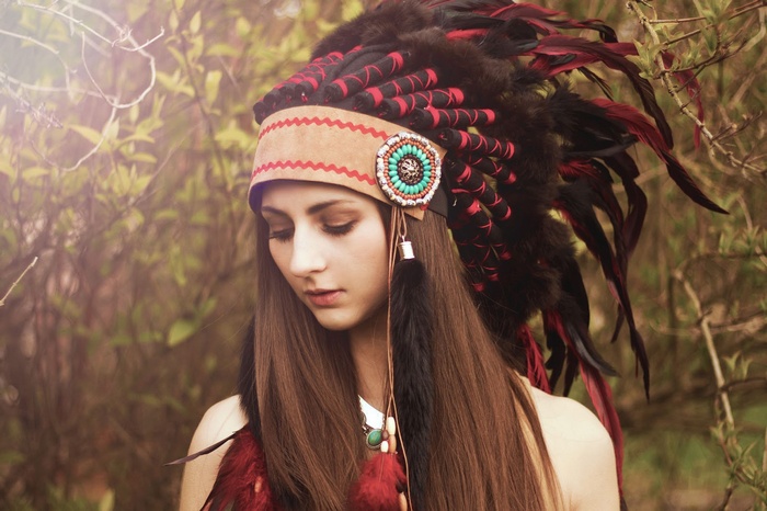 Woman wearing a Native American headdress with feathers