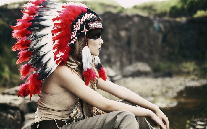 Woman wearing a Native American headdress with feathers