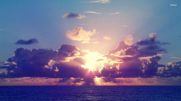 Sunlight breaking through clouds over the sea