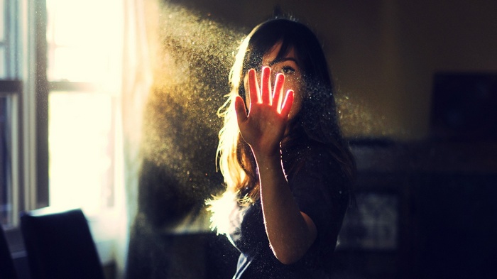 Woman's hand in sunlight with dust particles