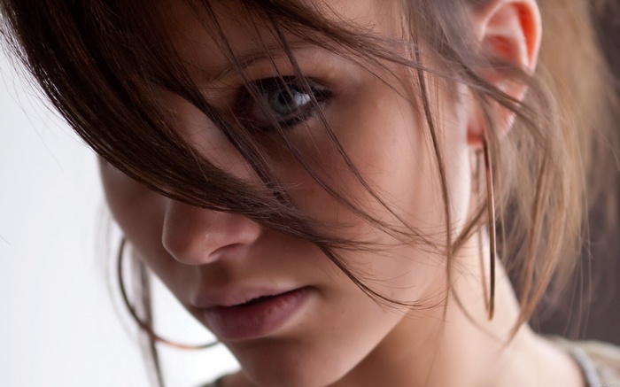 Brunette woman with hoop earrings looking at viewer