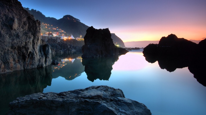 Coastal landscape with town lights reflecting in water