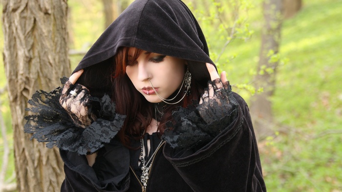 Redhead woman with gothic style and piercings outdoors