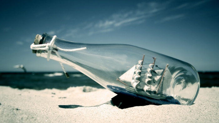 Ship in a bottle on a sandy beach