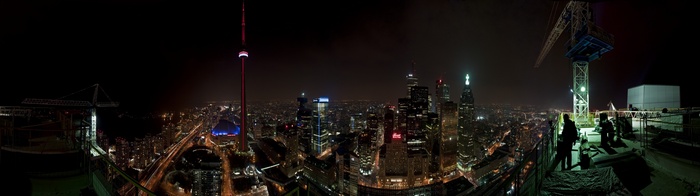 Toronto cityscape at night with CN Tower and crane