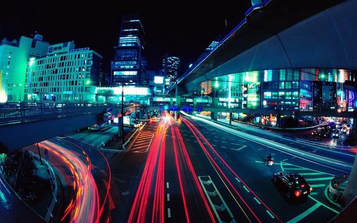 Tokyo cityscape at night with light trails from traffic