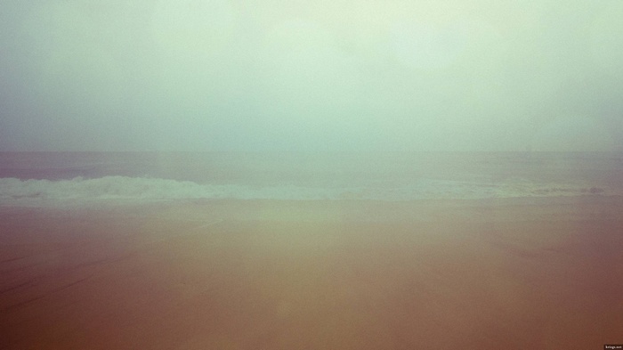 Misty beach with waves on the horizon