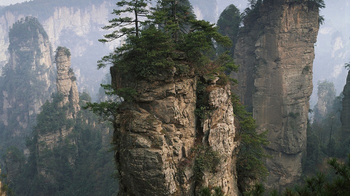 Misty mountains with tall rock formations and trees