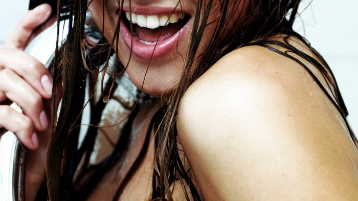 Woman with wet hair laughing in the shower