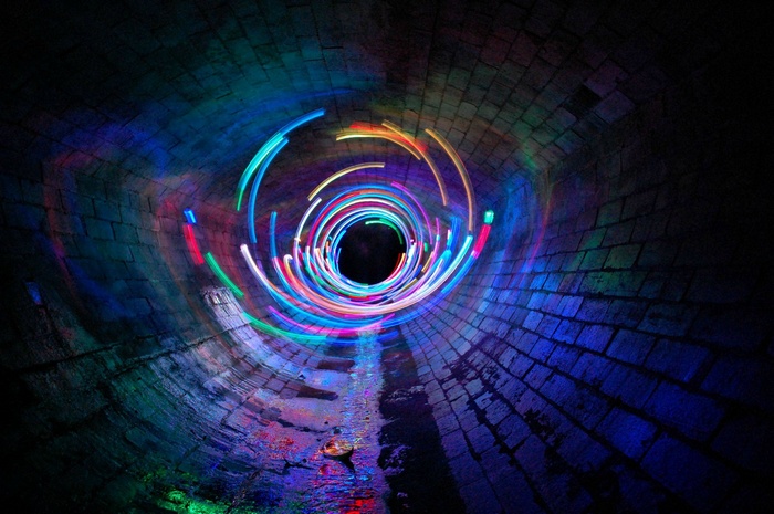 Light painting in a brick tunnel with colorful swirls